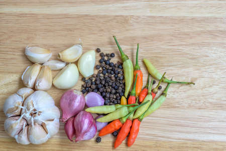 garlic onion pepper and spice isolated on wood backgroundの写真素材