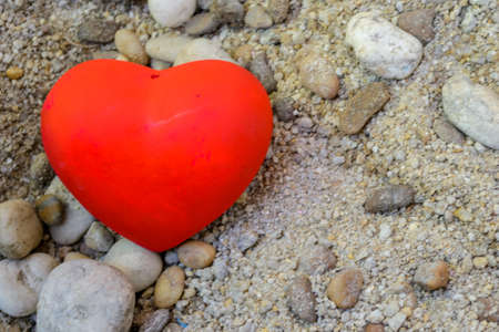 Red heart on sand and rocks backgroundの写真素材