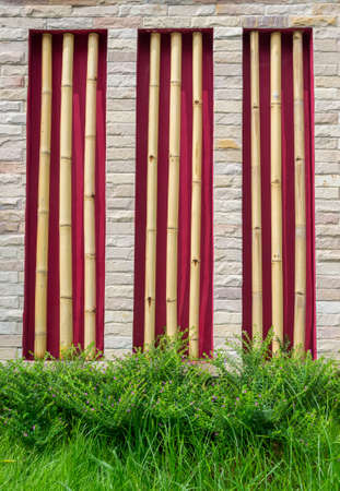 stone wall surface with cement and green grass backgroundの写真素材