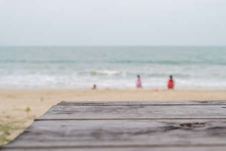 Wood table top with beach as blur backgroundの写真素材