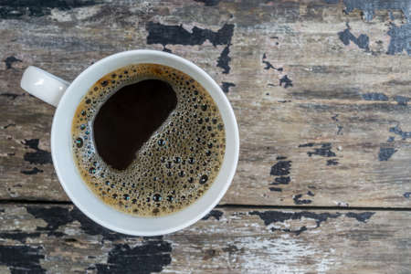 Black coffee in white cup on the old wooden tableの写真素材