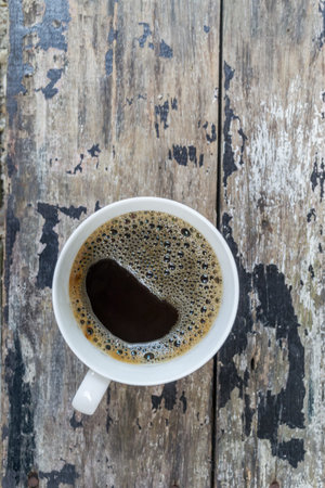 Black coffee in white cup on the vintage wooden table
