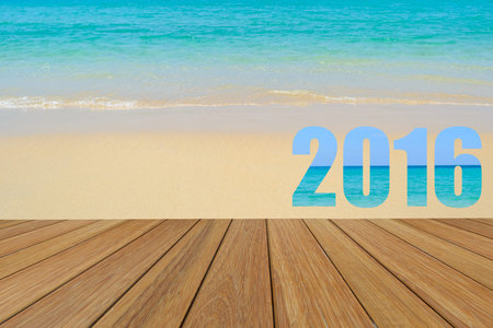 Happy New Year 2016 word created text from the sea picture on teak wood with beach