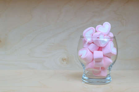 Marshmallow hearts in glass on wood tableの写真素材