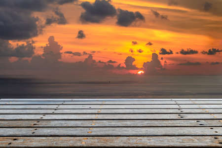 Wooden platform beside tropical sea with sunsetの写真素材