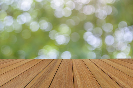 Wooden platform beside abstract blurred foliage background