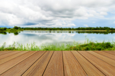 Wood table top on blurred Lake and sky background for presentation product.の写真素材