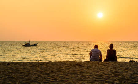 Couple watching the sunset on Nai Thon beach,Phuket in Thailandの写真素材