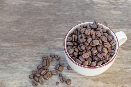 Coffee bean in cup on wood table backgroundの写真素材