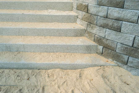 Concrete stairs with rocks beside and sand beachの写真素材