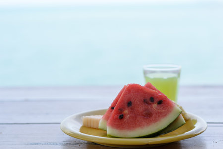 Slices of watermelon on dish with blur beach background