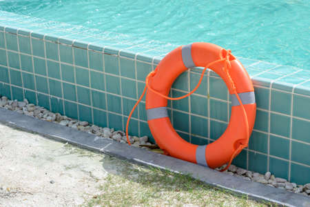 orange lifebuoy near swimming pool.の写真素材