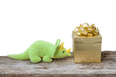 dinosaur toy and the gold box on wood backgroundの写真素材