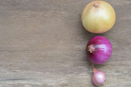Different types of onions on the wooden backgroundの写真素材