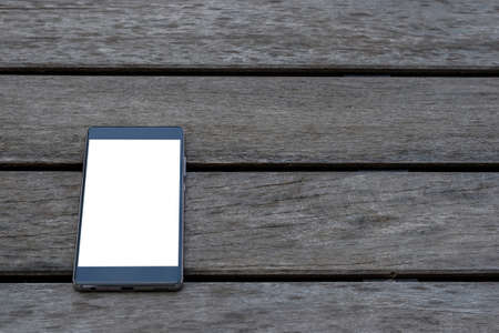 Top view new smartphone with blank screen on vintage wooden backgroundの写真素材