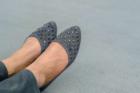 Close up of stylish female shoes with cement backgroundの写真素材