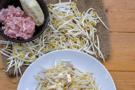 Tofu and pork chops prepared to use fried bean sprouts on wood tableの写真素材