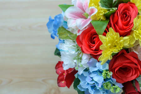 Colorful decoration artificial flower on wood backgroundの写真素材