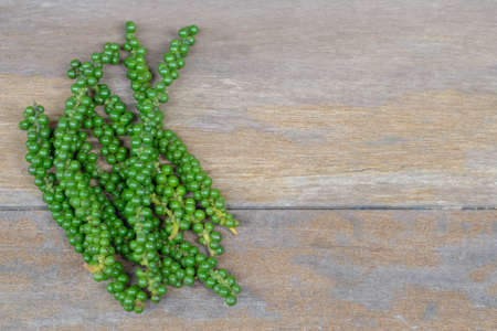 fresh green peppercorns on wooden tableの写真素材