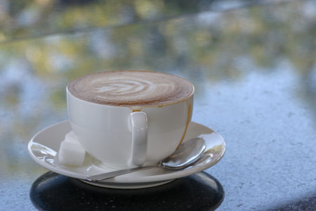 coffee on dark stone table with bokeh nature background