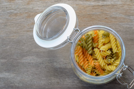 macaroni in glass jars on a wooden background.