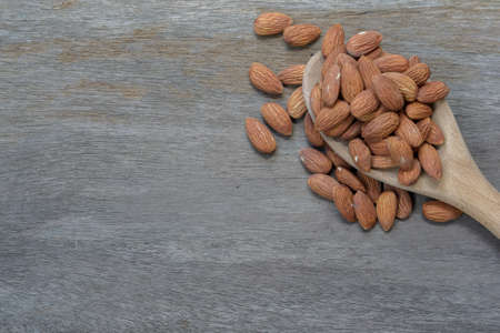 almond in wooden spoon on wood backgroundの写真素材