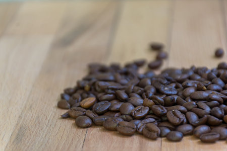 Selective focus of Roasted coffee beans on  wooden background with copy space.