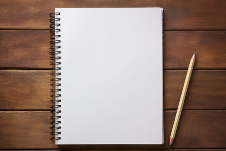 Blank notepad with pencil on brown wooden table, top viewの素材