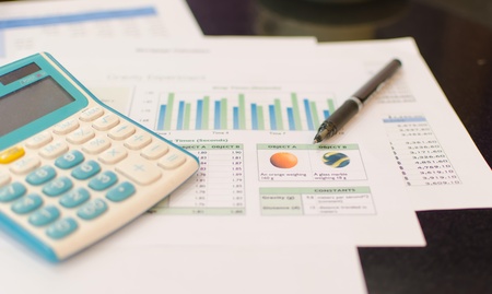 Report on Business  Calculator and pen on the table の写真素材