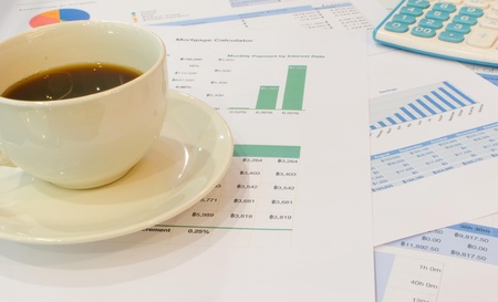 Cup of coffee and calculator on the document の写真素材