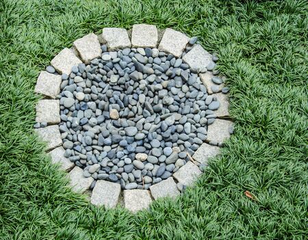 A small lawn with a stone in the middle の写真素材