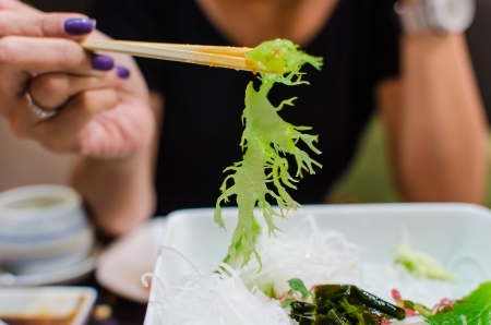 Japanese with chopsticks clamp green algaeの写真素材