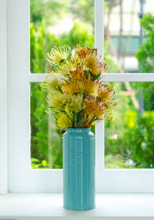 Flowers in a blue vase near the windowの写真素材