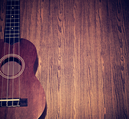 The ukulele is placed on a vintage wooden floor の写真素材