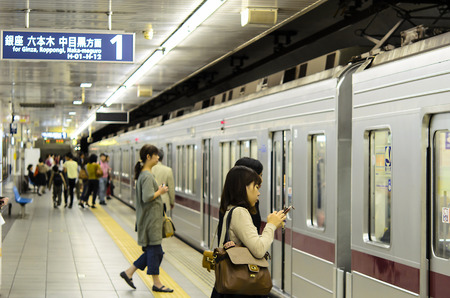 TOKYO - OCT 14: People wait in Tokyo Metro on October 14, 2013 in Tokyo. With more than 3.1 billion annual passenger rides, Tokyo subwayのeditorial素材