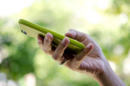 smart phone in hand on green background.の写真素材