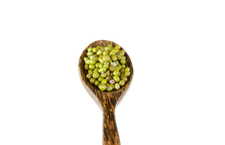 Green mung beans with wooden spoon on white backgroundの写真素材
