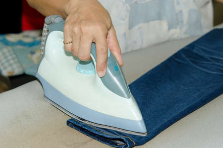 Jeans iron on the ironing board.の写真素材