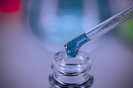 Laboratory research Blue water drops on the glass tube.