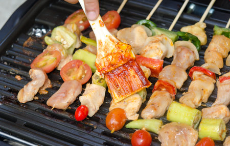 Grilling chicken on barbecue grill.