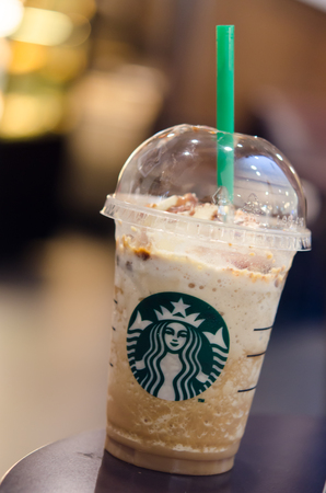 Bangkok ,Thailand-AUGUST 1 : Glass of Starbuck Coffee Frappuccino Blended Beverages served at wood table in starbuck shop at Seacon Department store, Bangkok, Thailand.のeditorial素材