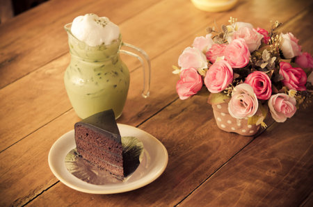 Chocolate cake and iced green tea on the table.film style color effectの写真素材