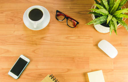 Business desk with  mouse and smart phone on wooden tableの写真素材