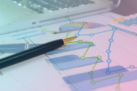 Financial graphs analysis and pen.