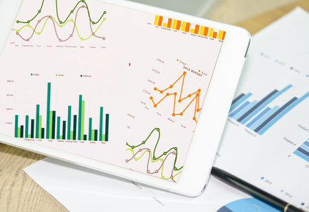 Business charts and diagrams on digital tablet.