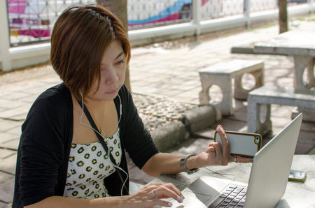 attractive young woman using laptop outside