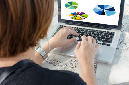businesswoman analyzing graphs on laptopの写真素材
