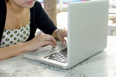 Close up of business woman hand working on laptop computerの写真素材