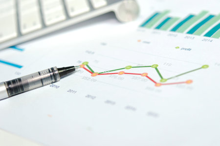 Financial graphs analysis and pen.