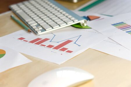 Documents, graphs and keyboard on a desk.の写真素材